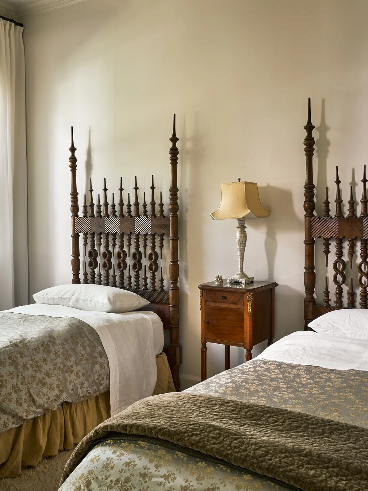 Guest bedroom in an Austin interior design project featuring twin vintage Portuguese wood beds, a central antique nightstand, and layered Bella Notte linens styled by Laura Roberts Design.