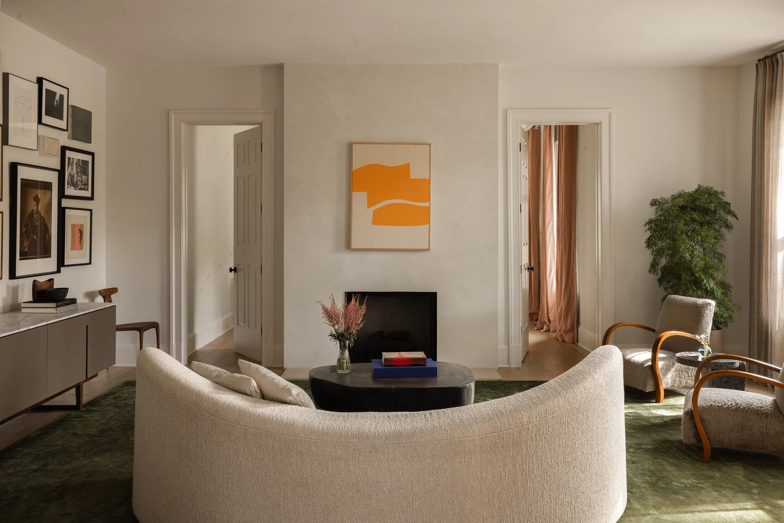 Mclean living room with gallery salon wall, Ethan Cook painting on plaster fireplace, vintage chairs, and a moon sofa from Les Atelier Courbet by Austin Interior Design firm, Laura Roberts Design