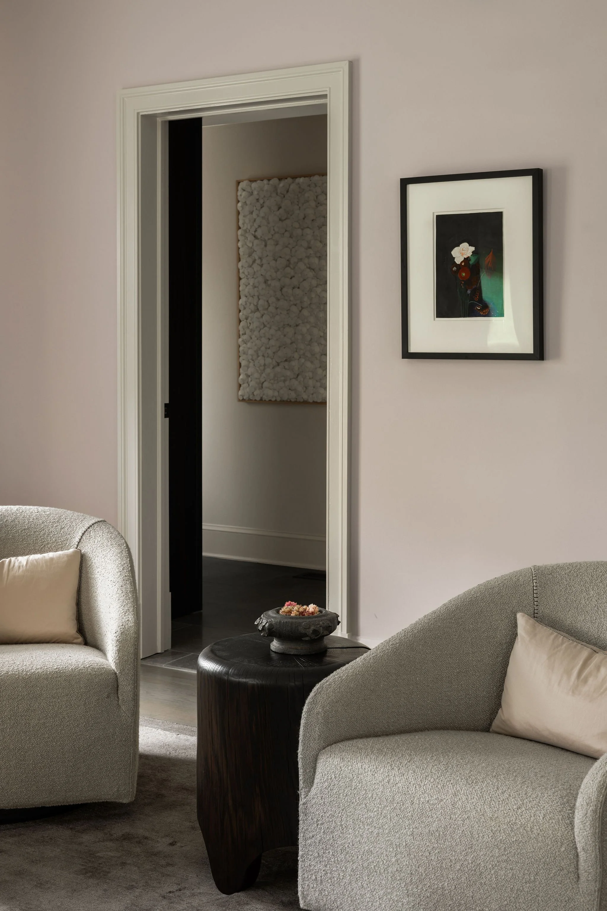 Primary bedroom sitting area with Minotti lounge chairs and a Joseph Stella painting, opening to the primary closet and bath with a large paper work by Kaku.