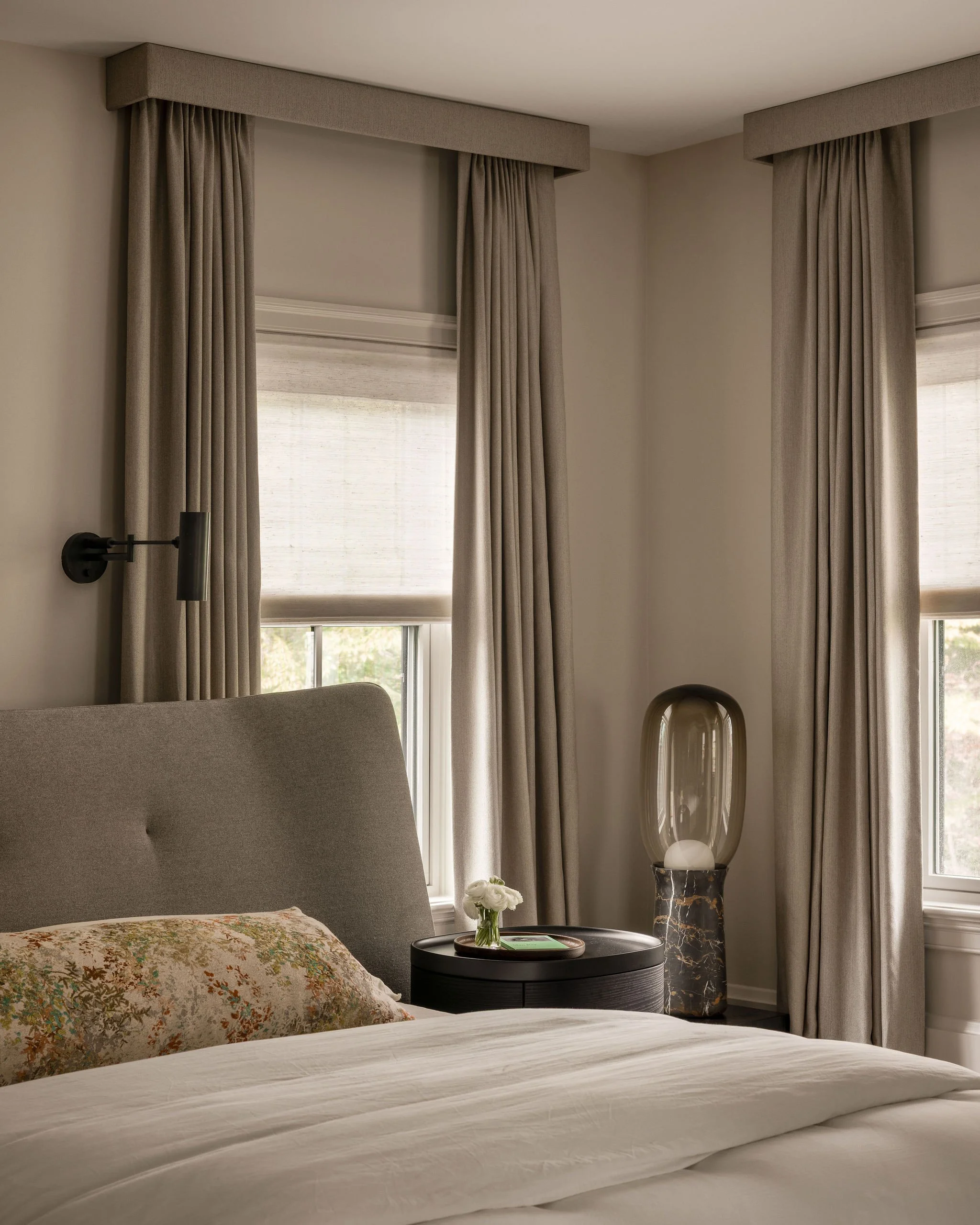 Primary bedroom vignette in a McLean, VA home featuring a custom Poliform upholstered bed, tailored window treatments, sculptural sconces by Apparatus, and a statement floor lamp by Modern Relik.