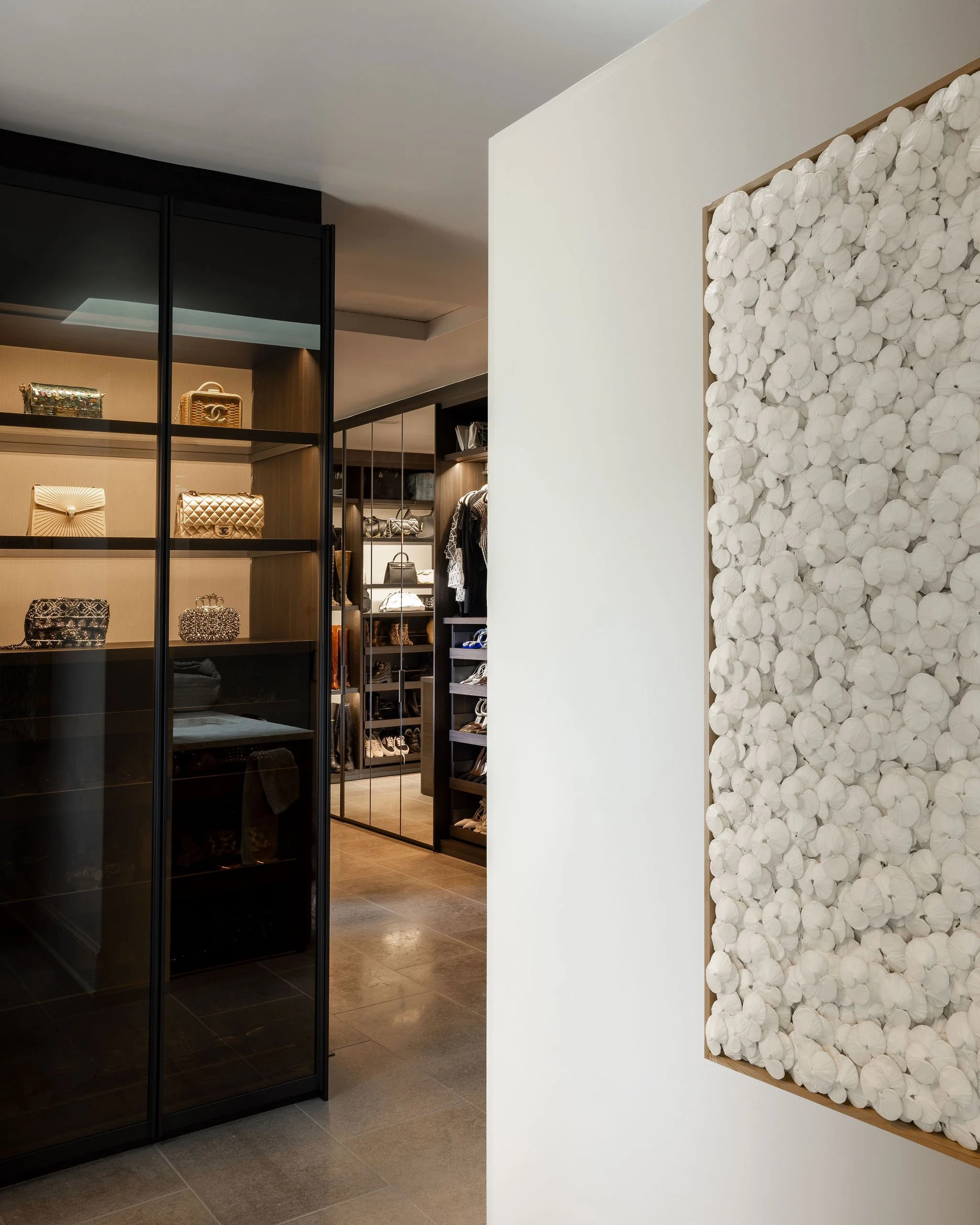 Entry to the Poliform Senzafine primary closet featuring a sculptural paper artwork by Kaku.