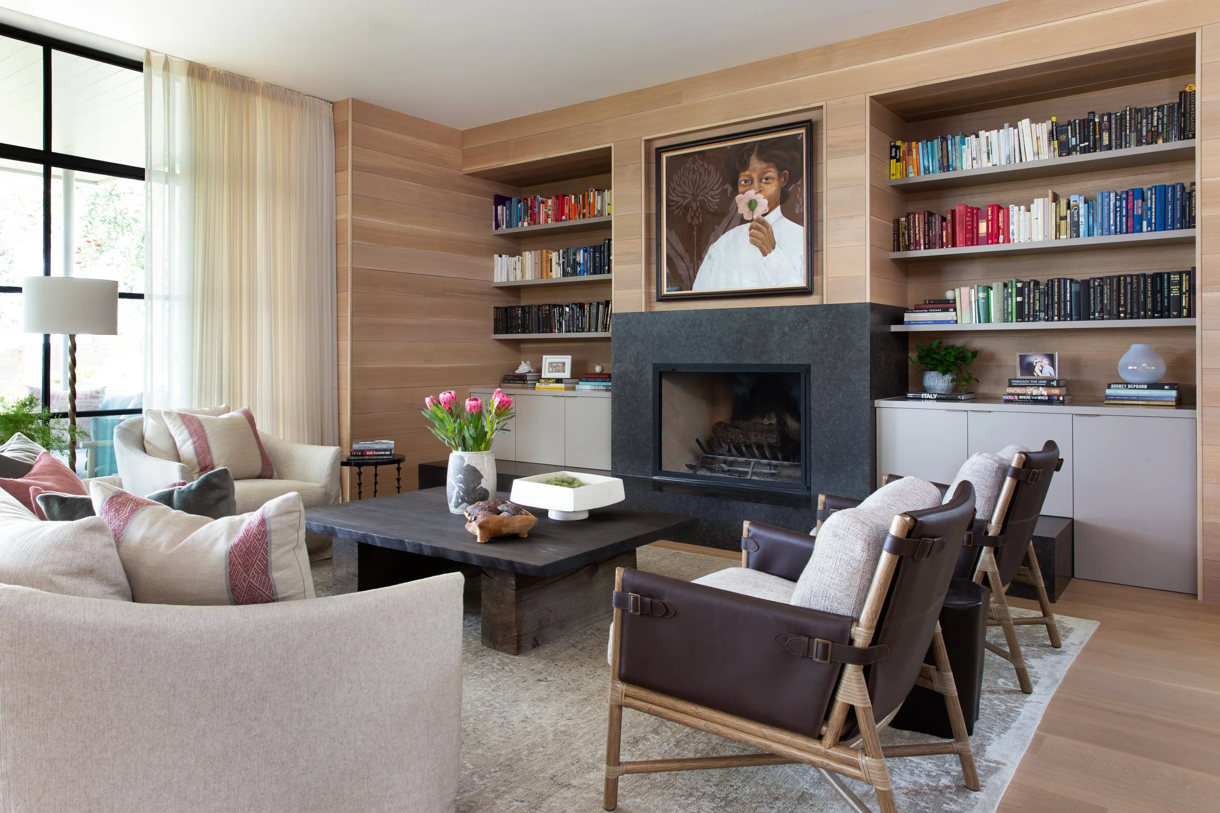 Austin living room with custom sofa, Belgian bluestone fireplace, white oak built-in bookshelves, McGuire leather and fabric armchairs, and custom coffee table.