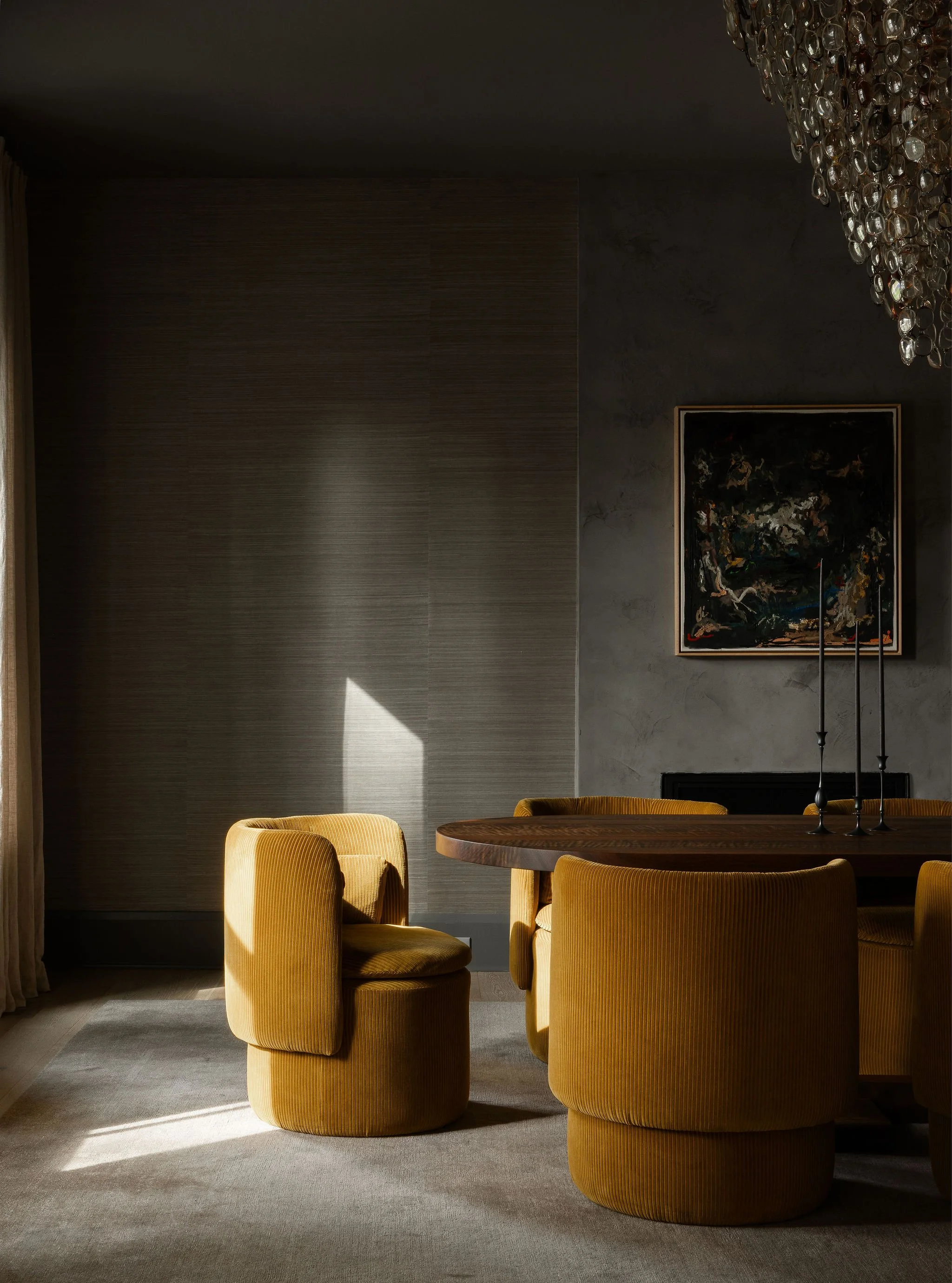Moody dining room in a McLean, VA home with dark grasscloth walls, the Spectacle chandelier by Stuart Haygarth made from vintage eyeglasses, a commissioned abstract painting by Hue Thi Hoffmaster, a custom walnut dining table, upholstered chairs