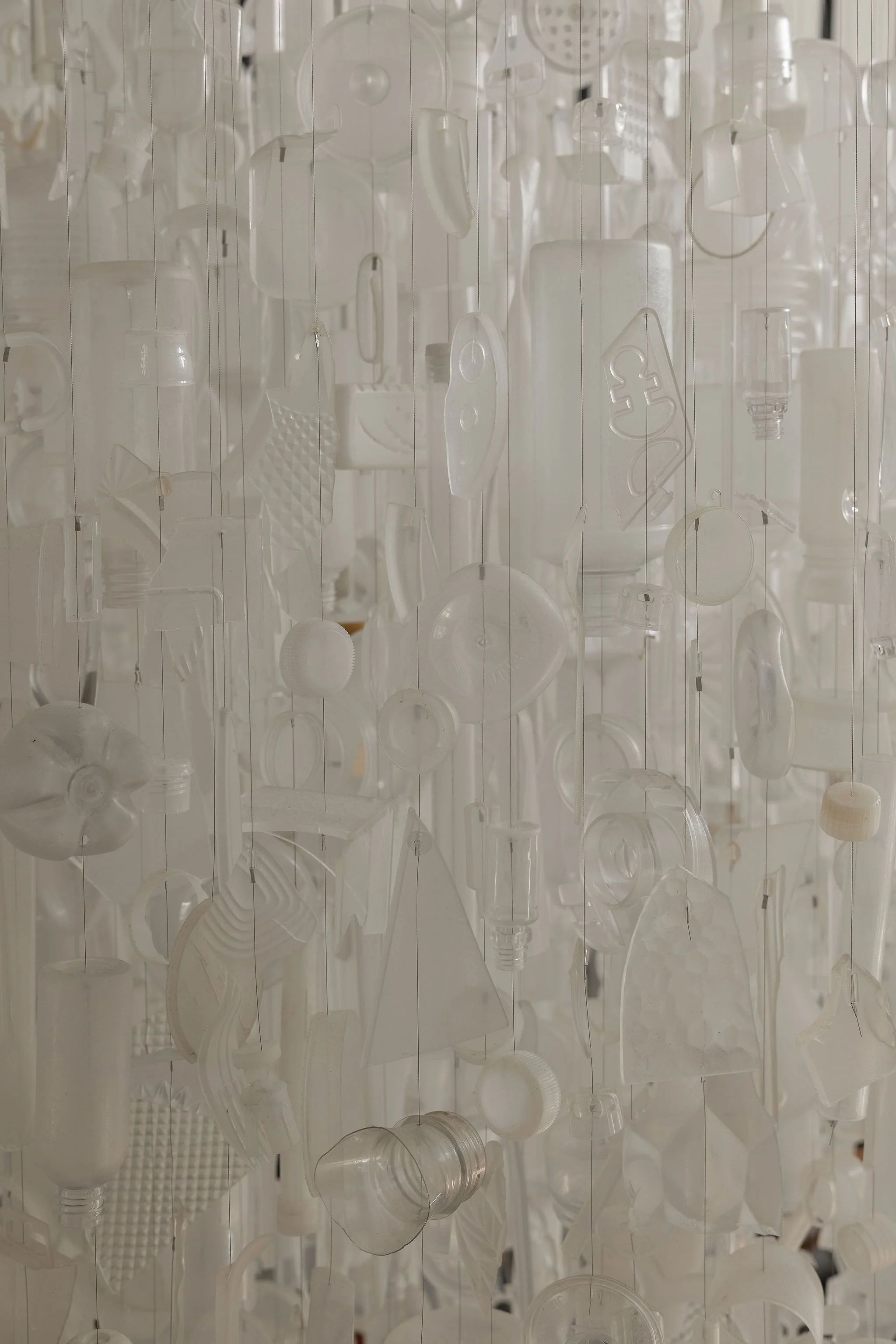 Close-up of the Tide chandelier by Stuart Haygarth, composed of reclaimed plastic bottles and everyday objects collected from shorelines.