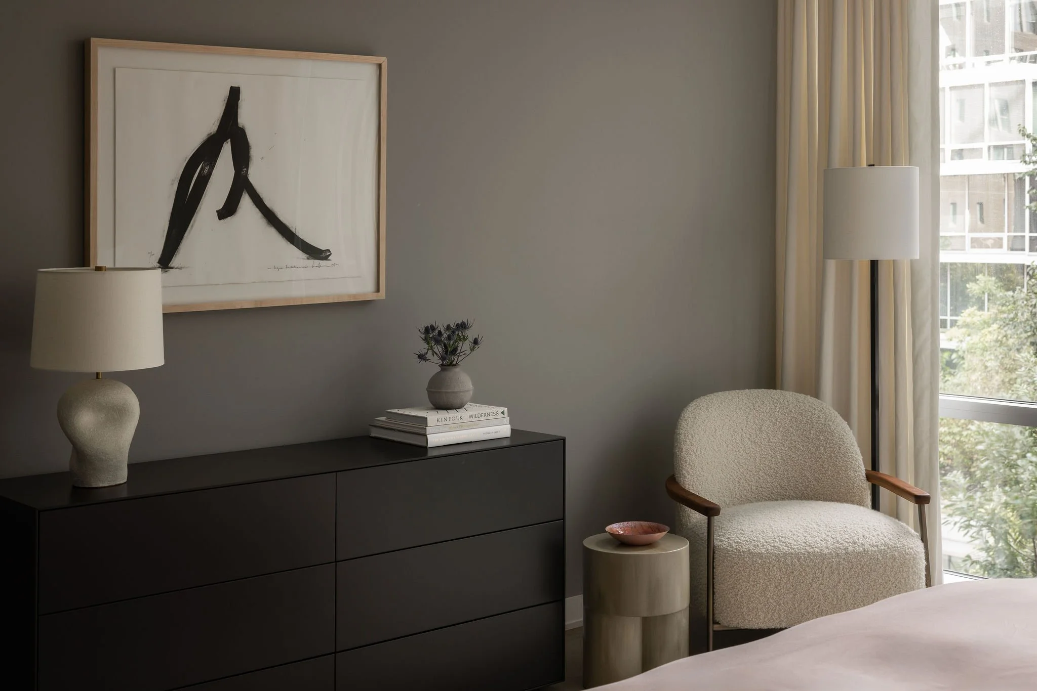 Guest bedroom in a Georgetown condo by Austin interior designer Laura Roberts Design, featuring a modern black dresser, sculptural ceramic table lamp, and a framed Bernar Venet print styled with soft neutral furnishings.