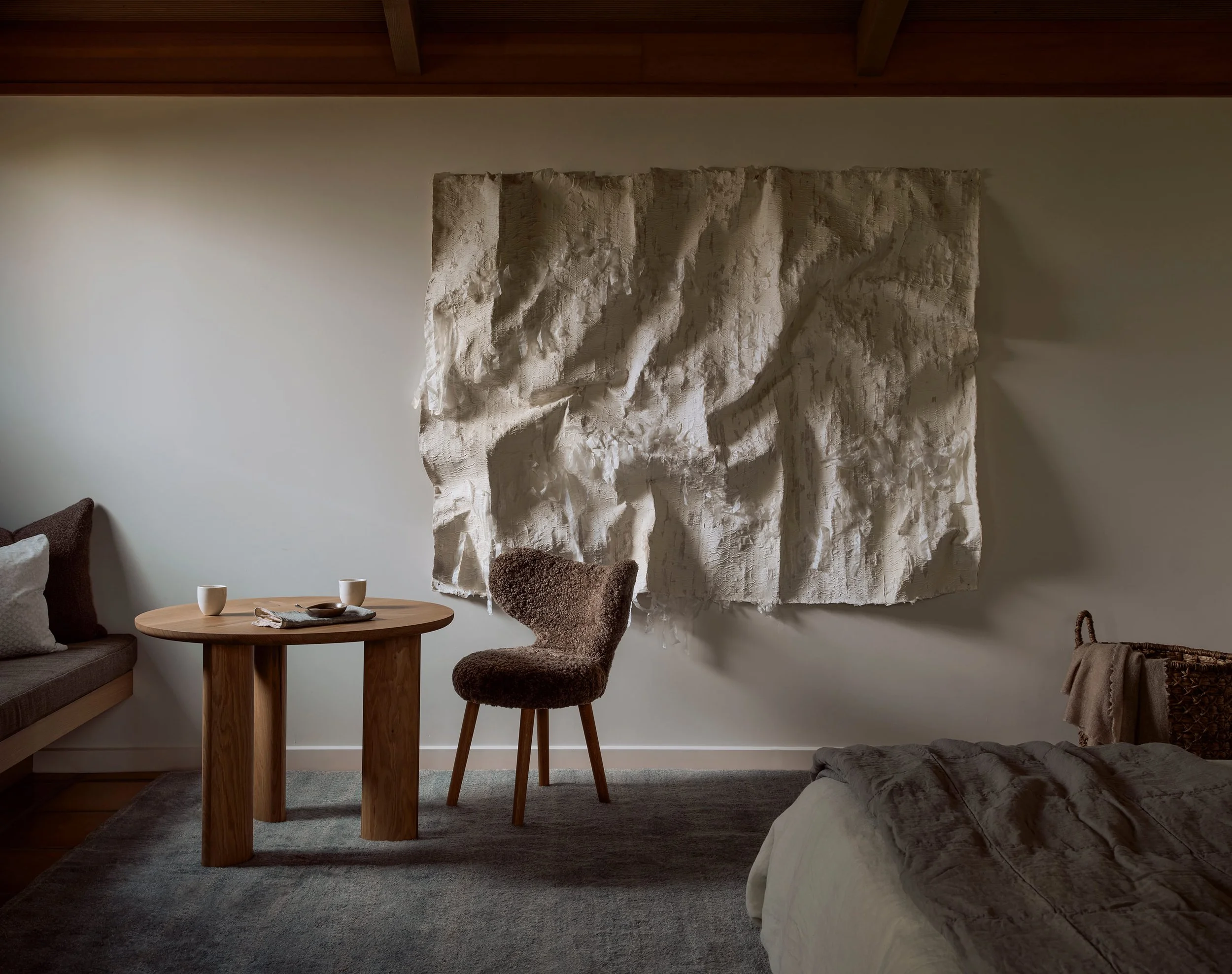 Kenny Nguyen tapestry anchors a Sonoma primary bedroom with custom furniture and lambskin chair by Austin Interior Designer Laura Roberts Design