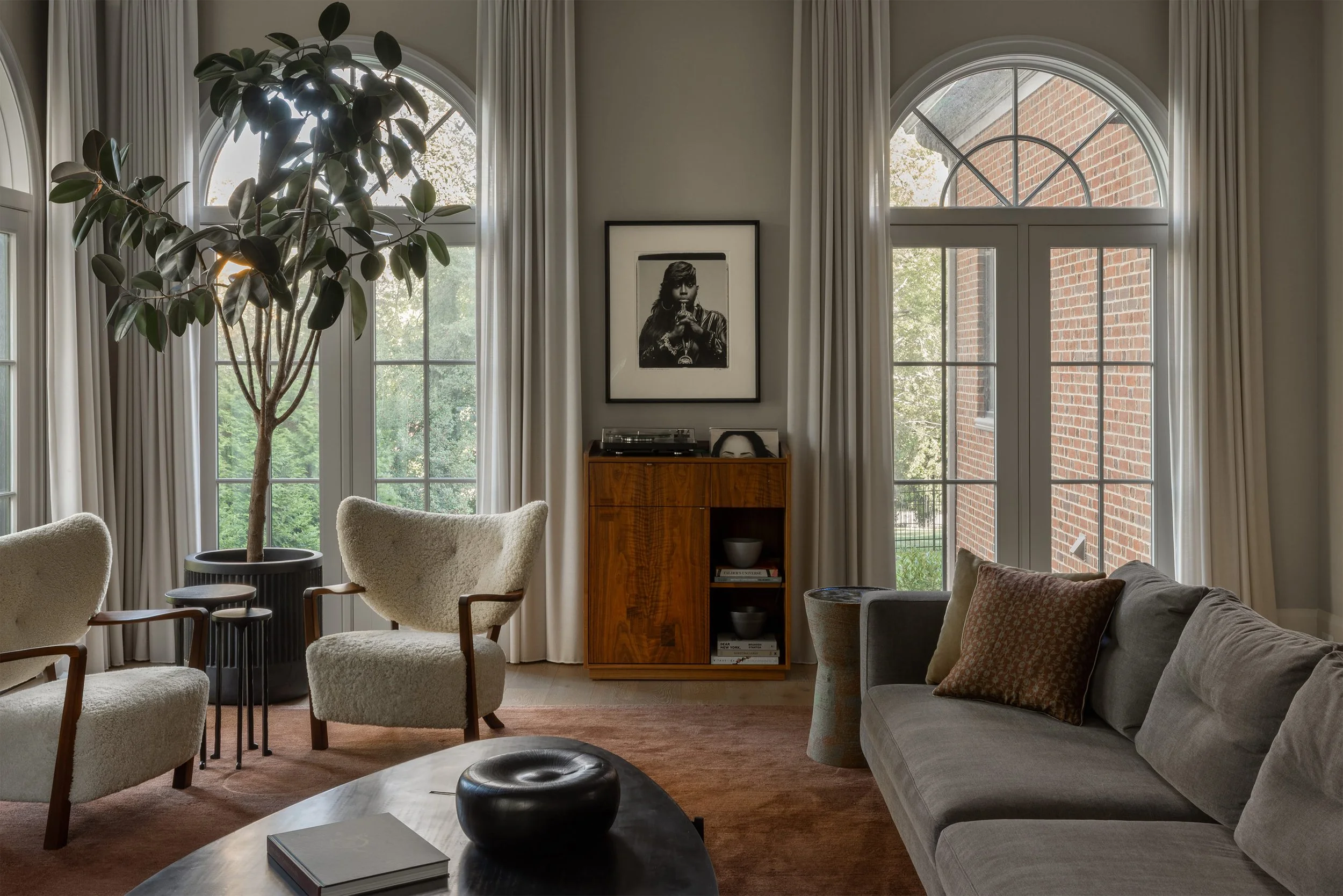 Modern living room with custom walnut record cabinet, sculptural lounge chairs, and black-and-white Missy Elliott photograph designed by Austin interior design firm Laura Roberts Design.