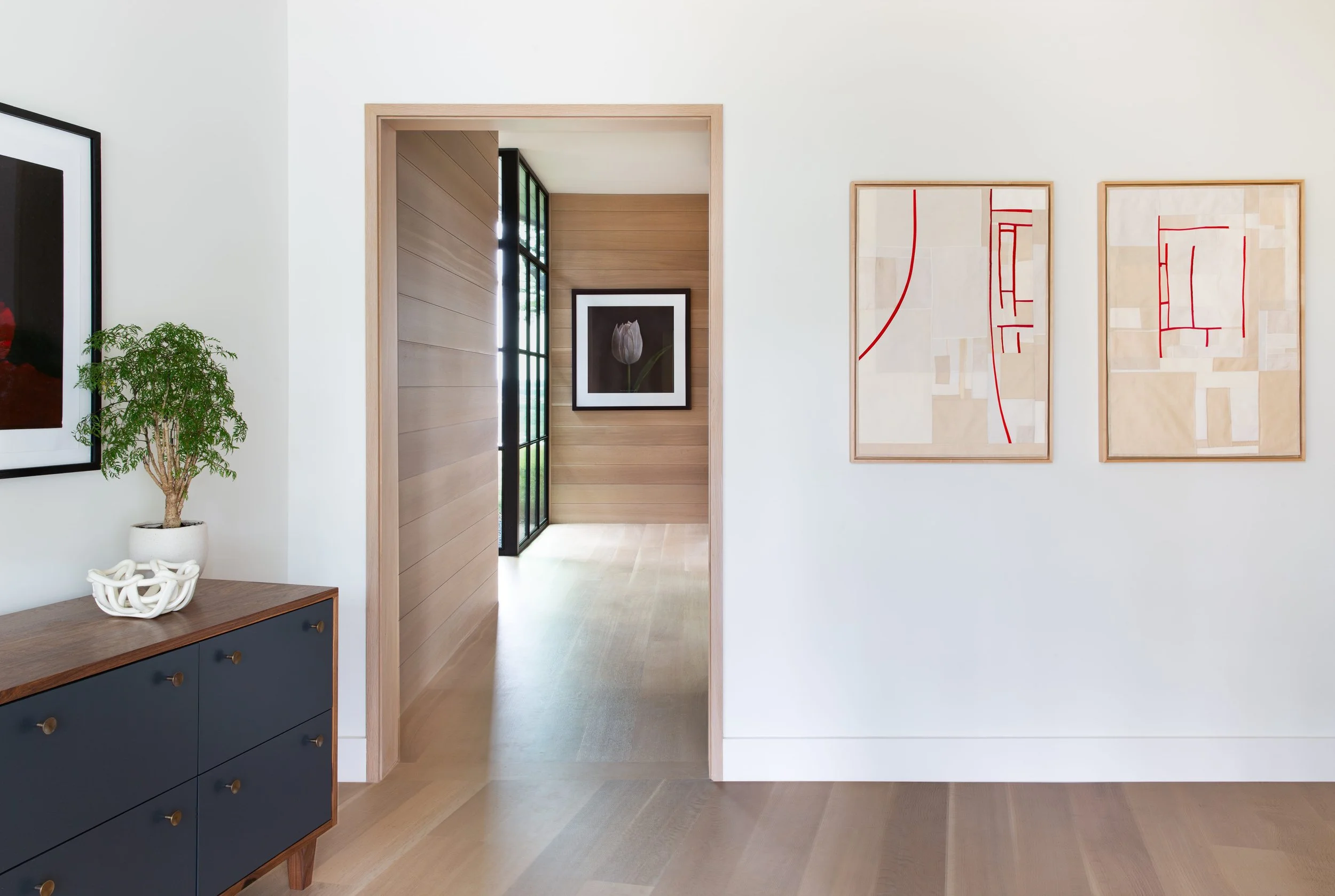 Austin entry foyer with white oak shiplap floors and walls, large steel window, Kate Breakey photograph, and modern textile art by Debra Smith connecting the home to nature.