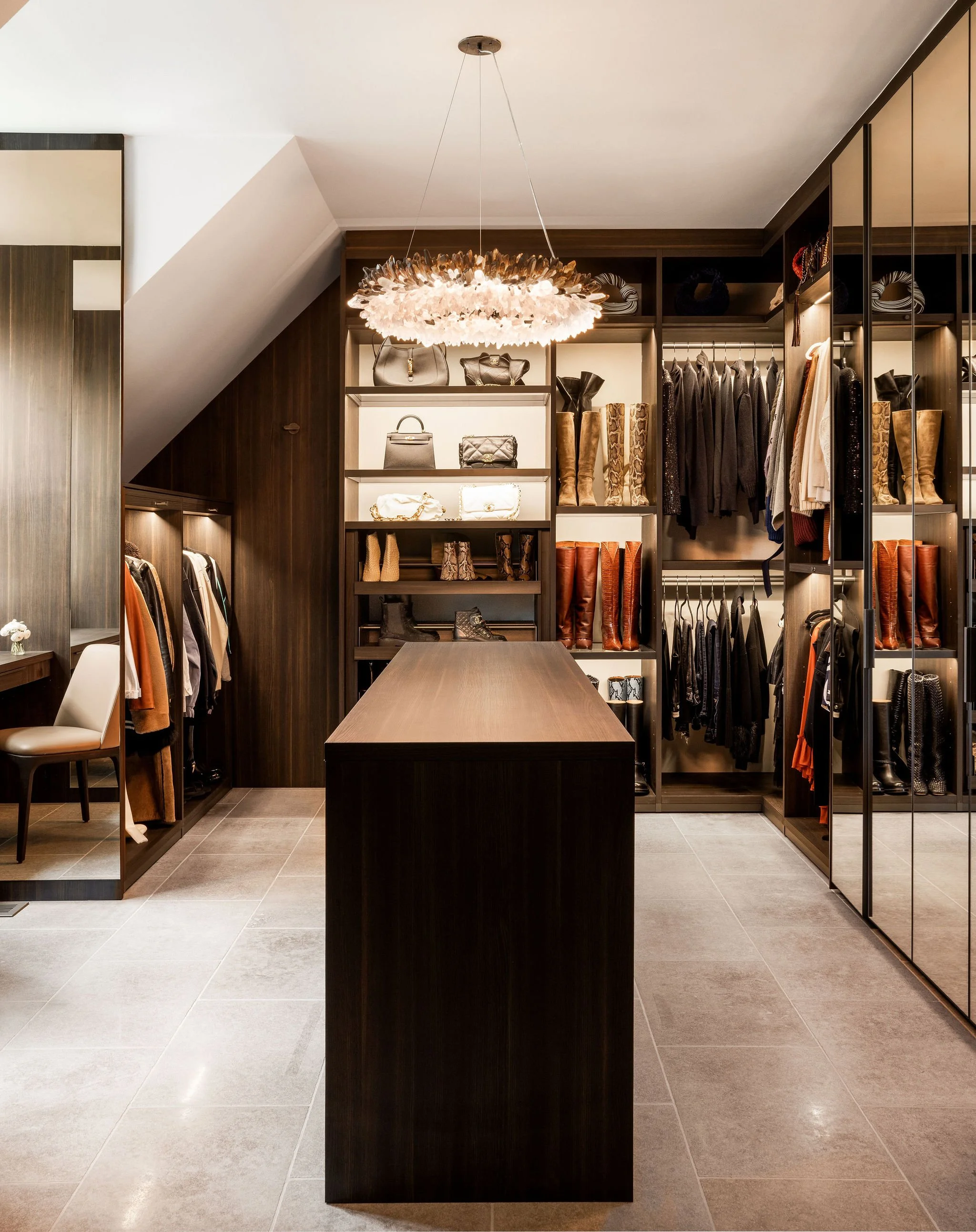 Custom Poliform Senzafine primary closet featuring stone floors, a central island, and a Christopher Boots smoky quartz diamond ring chandelier.