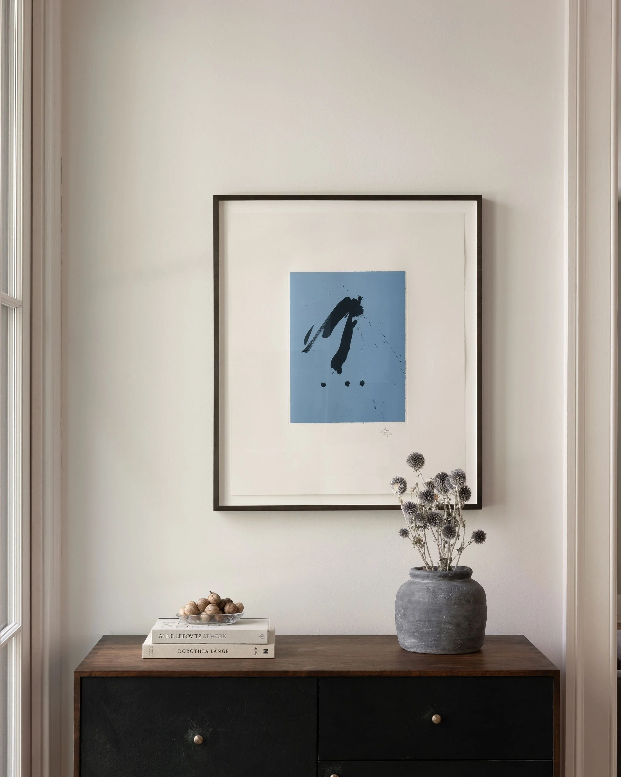 Custom blue leather–fronted chest in the kitchen topped with a framed Robert Motherwell print.
